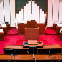 赤い絨毯が敷かれた格式ばった雰囲気の議場の写真