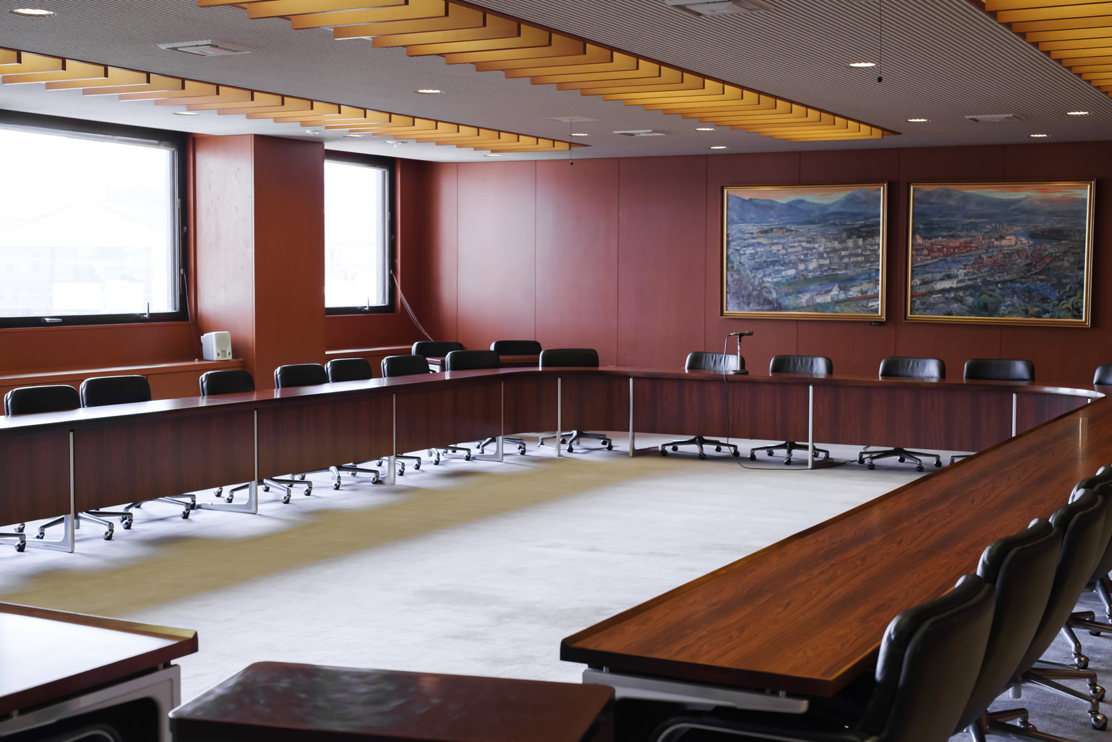 A wooden table and black chairs in the general meeting room of Tsuyama City Council