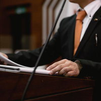 津山市議会の演壇で資料を手に発言する議員の姿の写真