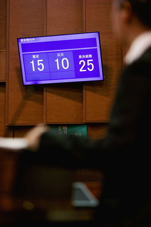 表決結果を映す電光板に目を疑う津山市議会議員