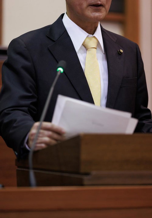 津山市議会の演壇で熱弁を振るう紺色スーツの男性議員