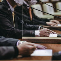 議員席で議論する市議会議員がマイクの前で熱弁を振るう場面の写真