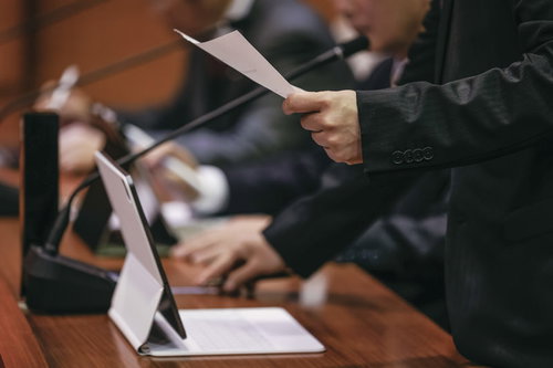 タブレット端末導入後も紙資料を併用して議論する津山市議会議員