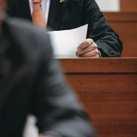 DXを推進すべきと印刷された紙を見つめる市議会議員の写真