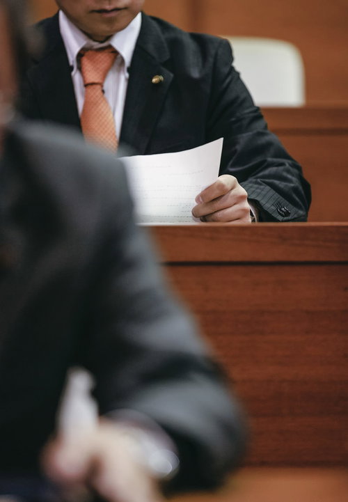 DXを推進すべきと印刷された紙を見つめる市議会議員