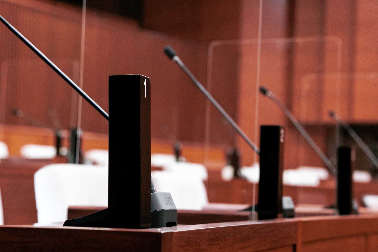 市議会の議場に配置された氏名標とマイク