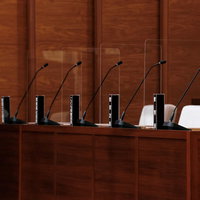 津山市議会の理事者席に並ぶ黒い氏名標とマイクの写真