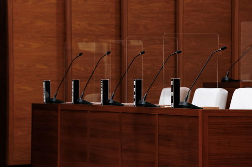 津山市議会の理事者席に並ぶ黒い氏名標とマイク