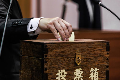 投票箱に清き一票を投じる市議会議員の民主主義実践