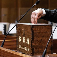 津山市議会の歴史ある木製投票箱に投票する手の写真