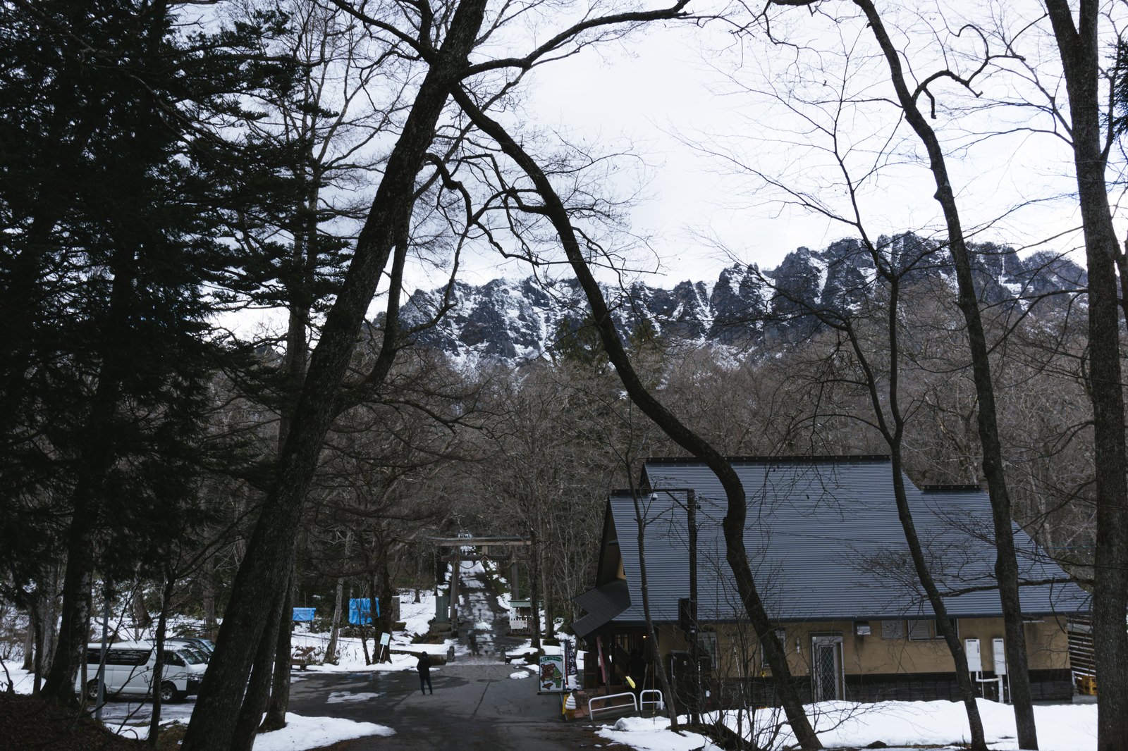 初冬の戸隠神社奥社入り口付近の朱色の鳥居と雪をまとった戸隠の山々