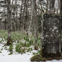 雪の残る戸隠神社奥社参道脇に建つ高妻山神鏡碑の写真