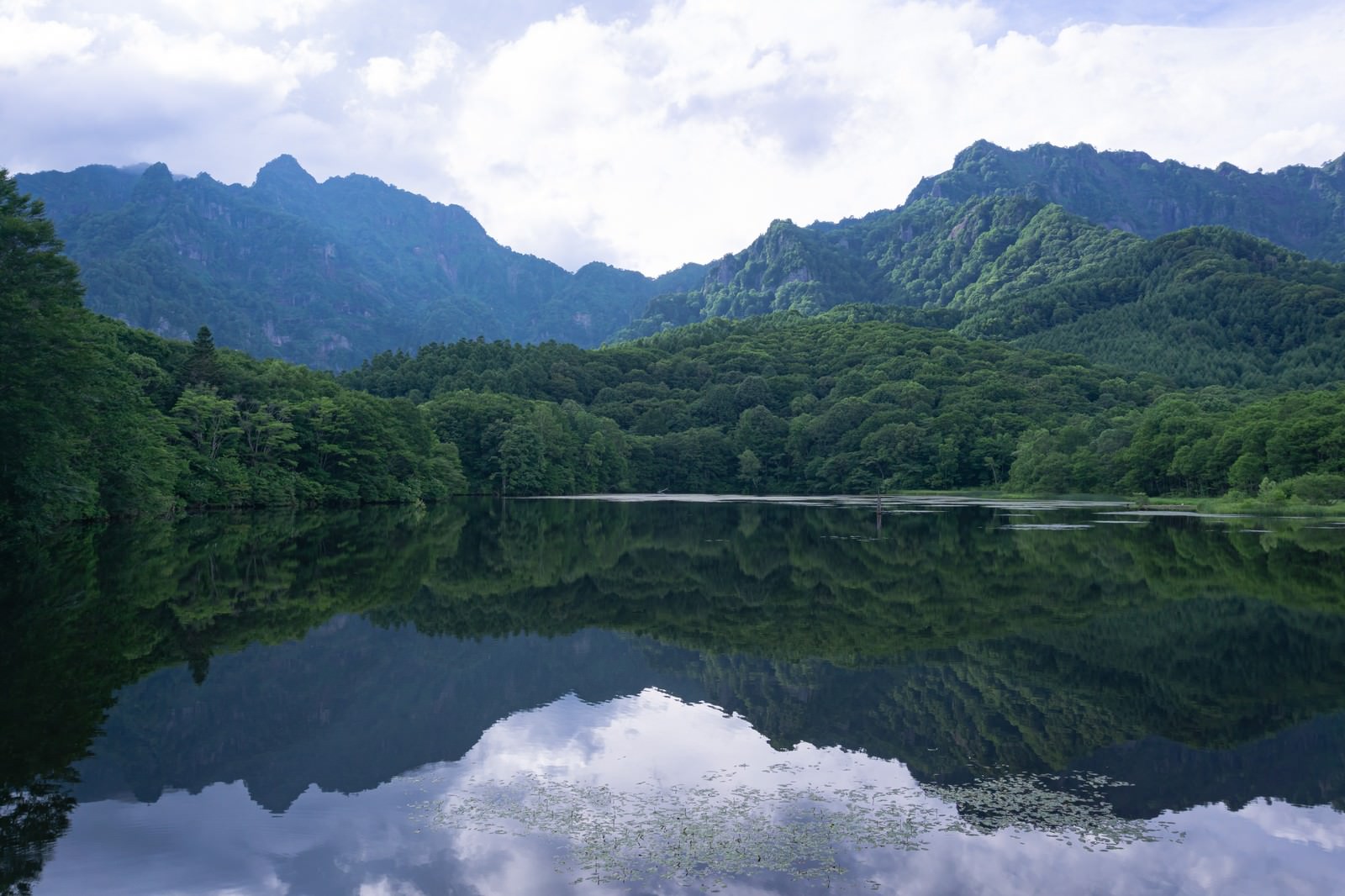 長野県戸隠の鏡池で山々と森林が水面に映り込むリフレクション