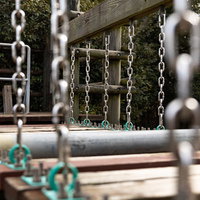 鎖で繋がれた木製板のアスレチック吊橋、金属チェーン支柱の写真