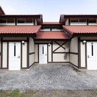 崎野自然公園の5連バンガロー、白い壁と赤い屋根の宿泊施設の写真