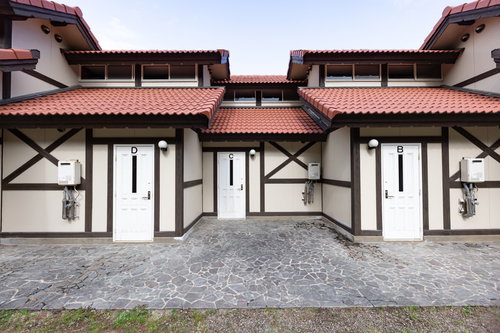 崎野自然公園の5連バンガロー、白い壁と赤い屋根の宿泊施設