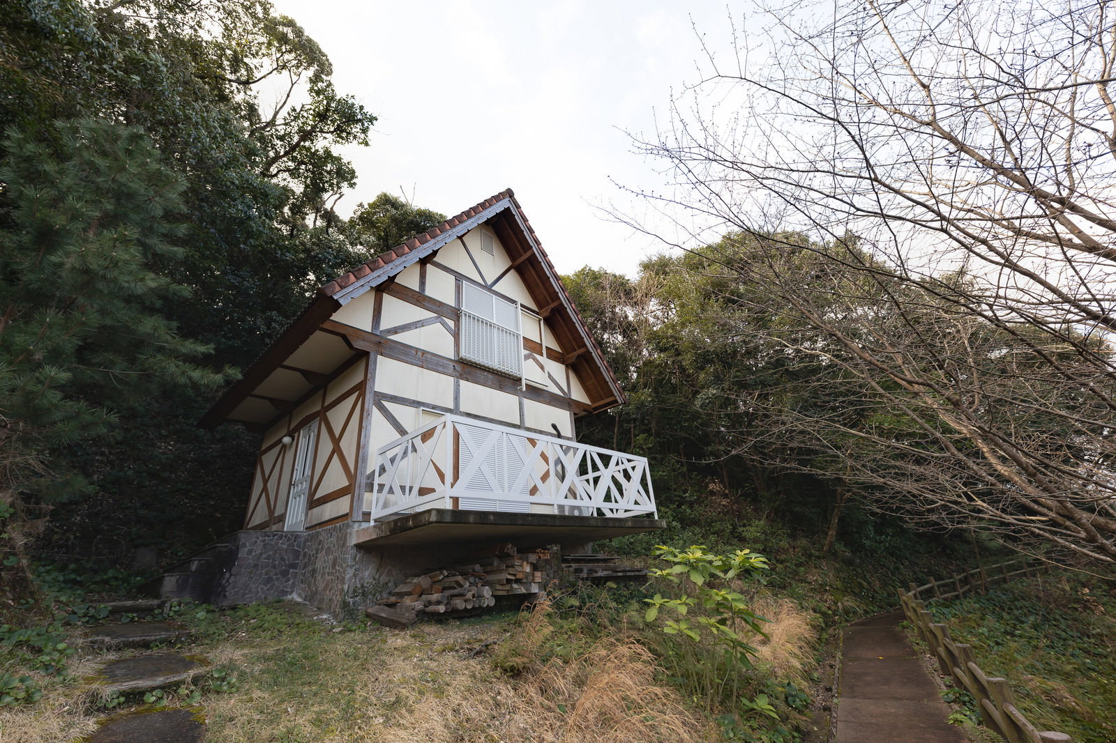 森の中に建つ白い外壁と茶色い屋根のバンガロー