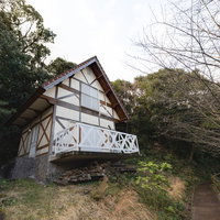 森の中に建てられた白い外壁のバンガロー（崎野自然公園）の写真