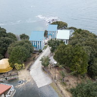 海を見下ろす崎野自然公園のコテージ群と海岸風景の写真