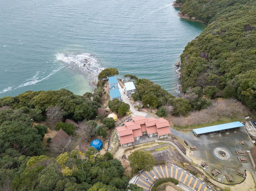 崎野自然公園キャンプ場の赤い屋根コテージと海岸の空撮