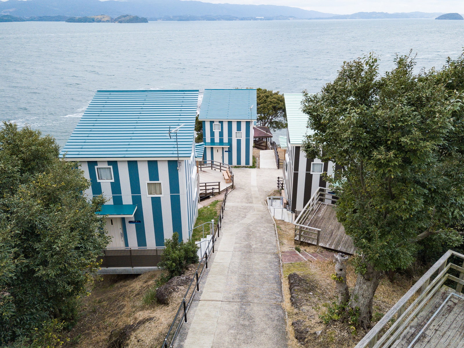 海岸沿いのキャンプ場に建つ青と白のストライプ模様のコテージ
