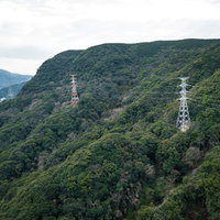 山間に立つ送電線と鉄塔の風景 - 山地を通る電力インフラの写真