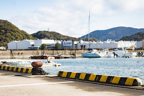 大村湾漁協組合前の海に停泊する漁船と緑の山々