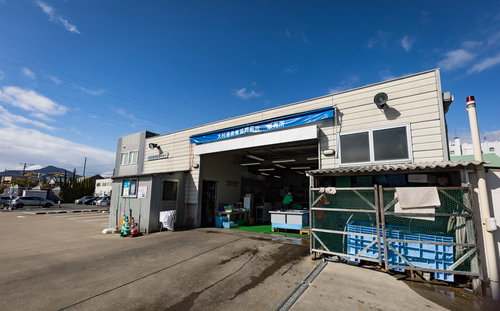 青空に映える大村湾漁業組合販売所の入り口