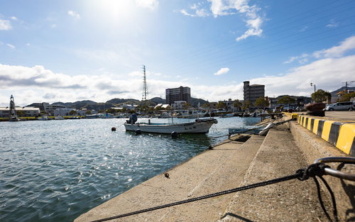大村湾の漁港に係留された漁船と防波堤の風景