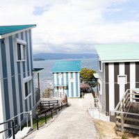 大村湾を眺める時津町の崎野自然公園、海岸沿いに並ぶコテージの写真