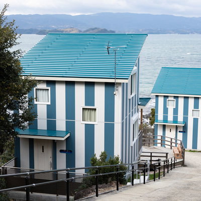 大村湾漁協組合前の海に停泊する漁船と緑の山々の写真素材 - フリー