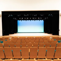 とぎつカナリーホールの1階正面席と舞台、音響反射板の写真