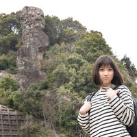 鯖くさらかし岩を背に迷子になる女性の写真