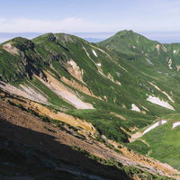 上富良野岳から眺める十勝岳連峰の稜線と残雪の写真