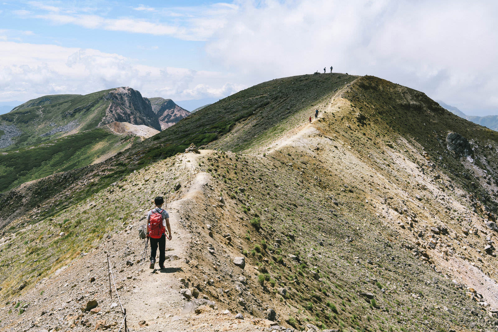 十勝岳の稜線を歩く登山者と上ホロカメットク山への登山道