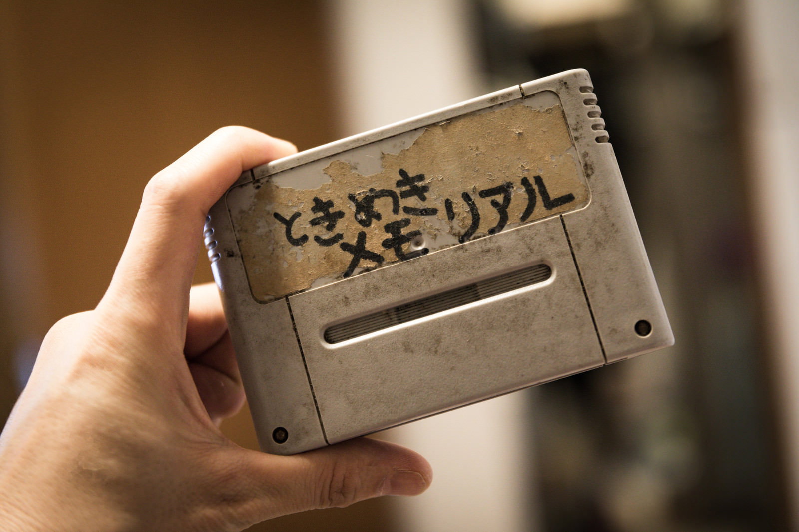 手に持たれた手書きラベルのゲームカセット