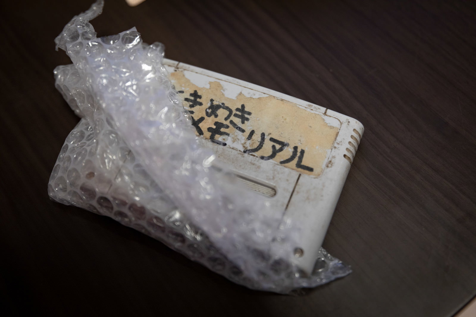 透明な袋に入った手書きラベル付きのファミカセが木目調の表面に置かれている