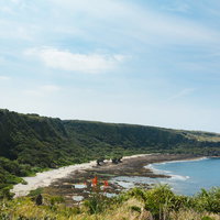 徳之島の犬の門蓋から一望する海岸線と青空の写真