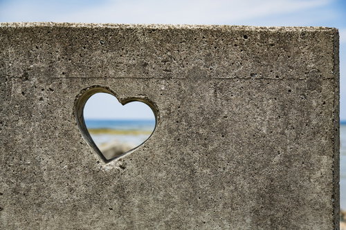 徳之島のコンクリート壁に開いたハートから見える池間の海