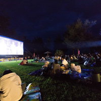 徳之島の夜空で野外映画を楽しむ観客たち、夜間の屋外シアターの写真