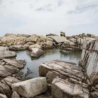 奄美十景ムシロ瀬の巨岩群と青い海。徳之島の花崗岩海岸の写真