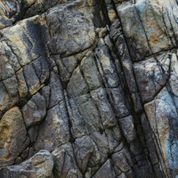 ムシロ瀬の岩に刻まれた亀裂とテクスチャ、風化による複雑な模様の写真