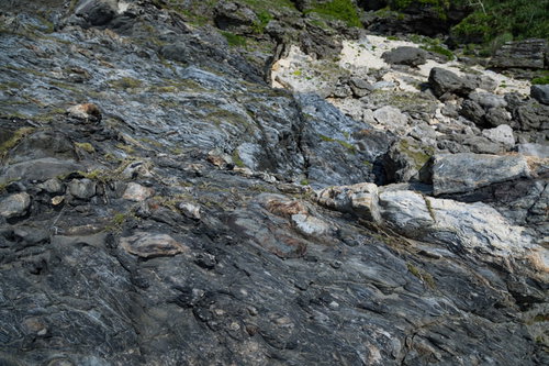 複雑に入り組んだメランジ堆積物の地層が重なる海岸の岩場