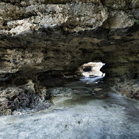 犬田布海岸に続く自然の岩場トンネルの写真