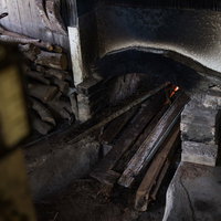 徳之島の製塩窯を沸騰させるために薪を入れる作業の写真