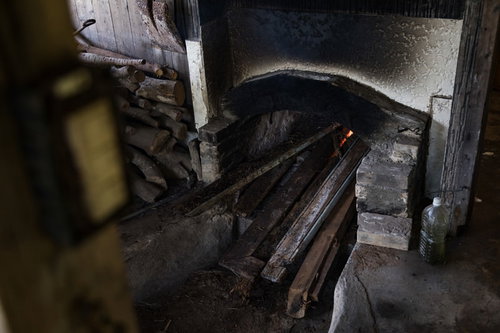 徳之島の製塩窯を沸騰させるために薪を入れる作業