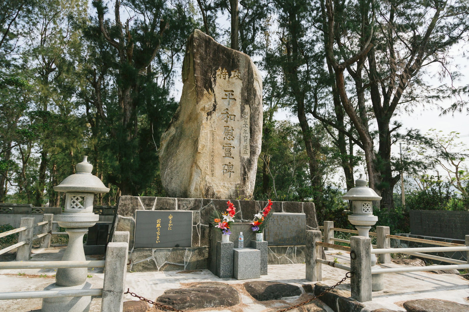 緑の木々に囲まれた旧陸軍浅間飛行場滑走路跡の石造慰霊碑