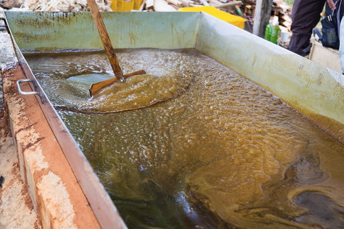 搾りたての黒砂糖を木のヘラでたく伝統製法