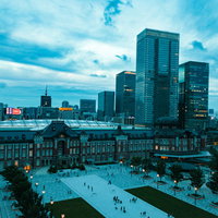 日が沈む東京駅前の高層ビル群と丸の内の都市夜景の写真