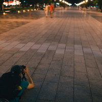 東京駅「丸の内駅前広場」を寝そべり撮影する外国人の写真